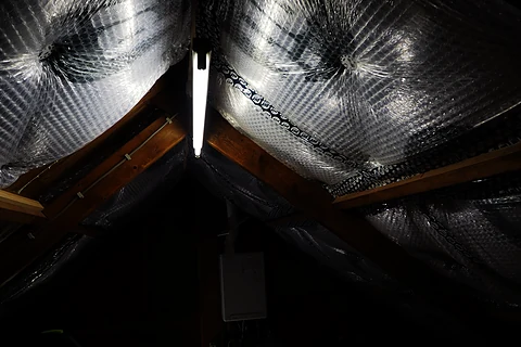 Afgewerkte dakisolatie met reflecterende folie tussen de sporen