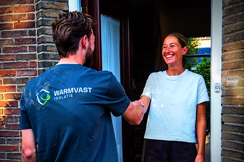 Warmvast-monteur en bewoner maken kennis bij de voordeur